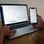 stock market trading on laptop and phone