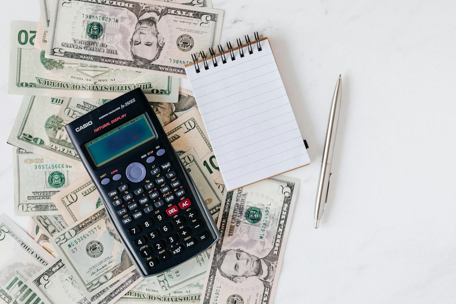 A calculator and cash being counted